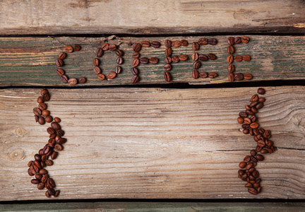 咖啡豆和木制背景上的杯子图片