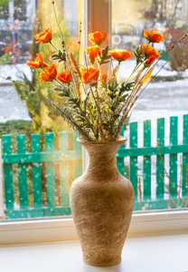 干燥冬季背景窗口上花瓶中的花