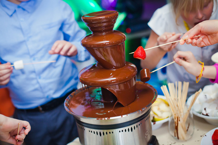 巧克力喷泉喷泉上孩子的充满活力的图片与孩子们玩耍的孩子生日聚会和