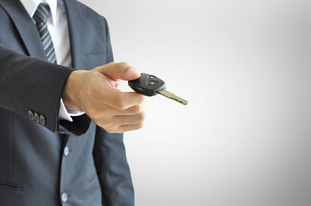 商人的手给一把车钥匙汽车销售及租赁业务概念