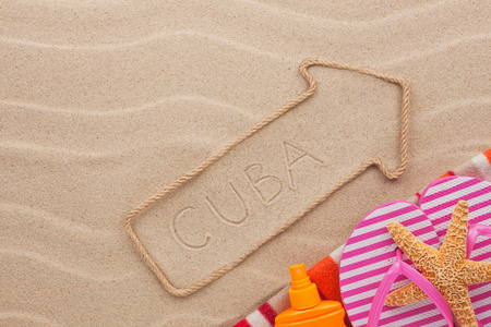 古巴指针和海滩配件躺在沙滩上