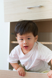 图片小男孩坐在衣柜里