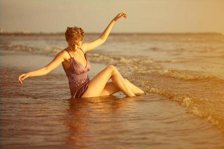 日落时海滩上的女人。