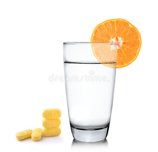 橙汁在玻璃杯里，橘子水果和维生素c片在白色的背景上