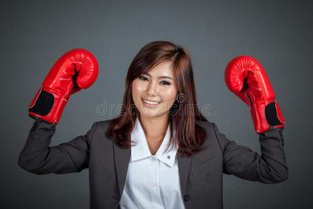 戴拳击手套的亚洲女商人露出拳头