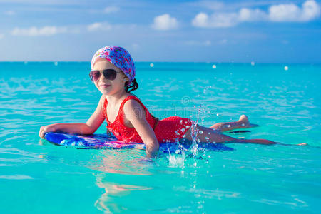 可爱的小女孩在冲浪板上