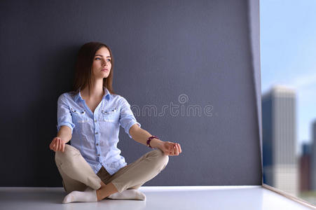 年轻女子坐在墙边的地板上