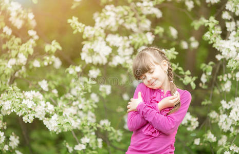 美丽温柔的女孩站在郁郁葱葱的花园里