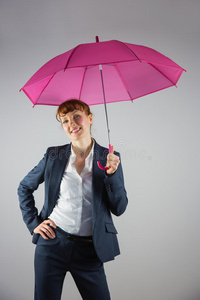 微笑的女商人举着粉红色的伞