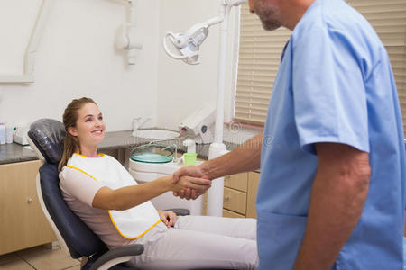 牙医在椅子上和病人握手