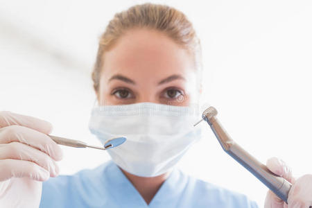 牙医在手术口罩里拿着工具对着病人