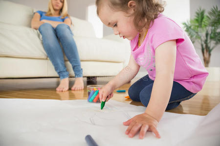 一个女孩在客厅里画画，妈妈坐在后面