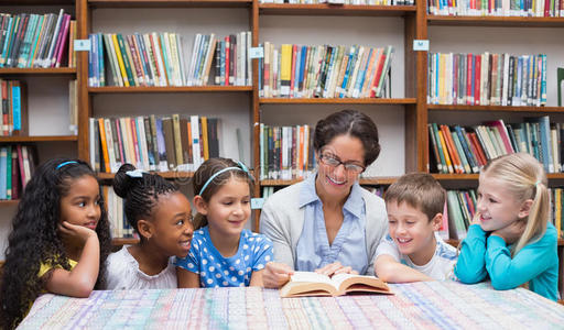 可爱的小学生和老师在图书馆看书