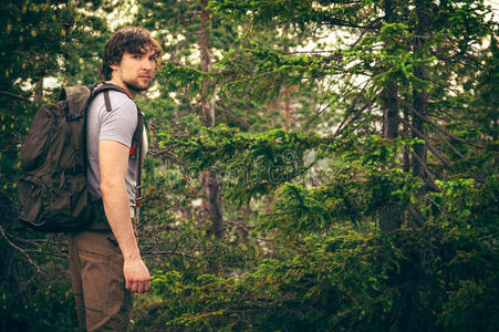 背着背包走在森林里的年轻人