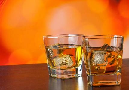 酒吧桌上的威士忌杯，在温暖的气氛中加冰
