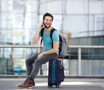 一个年轻人在机场用手机打电话