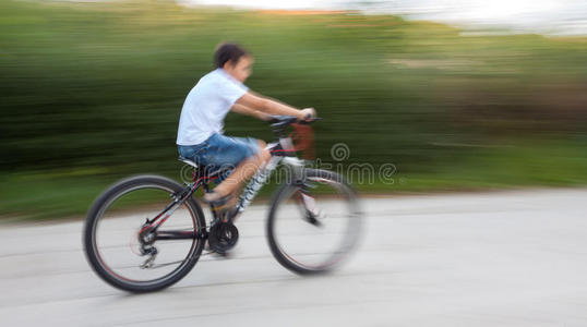 在城市道路上骑车的男孩