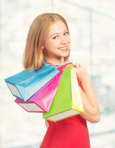 快乐的女人拿着包在购物中心购物