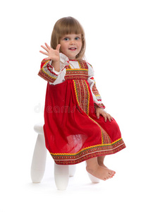 一个穿着红色传统服装的小女孩坐在椅子上