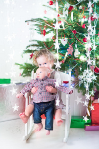 小女孩和她刚出生的弟弟在圣诞树下