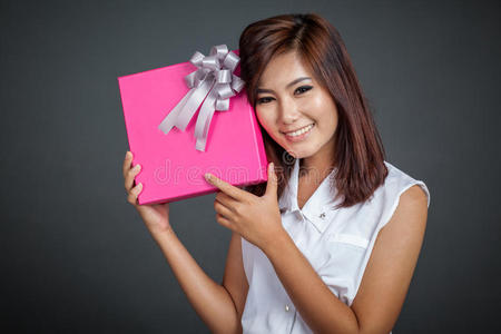 美丽的亚洲女孩开心地拿着礼盒