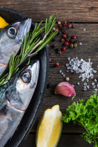新鲜鱼类的食物背景与草药烹饪概念
