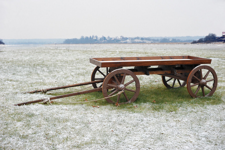在雪原的木制手推车图片