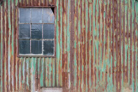 外部生锈铁皮墙上的一座建筑照片