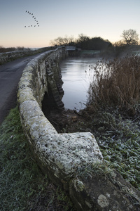 景观冬季 surnise 河和冷淡的字段