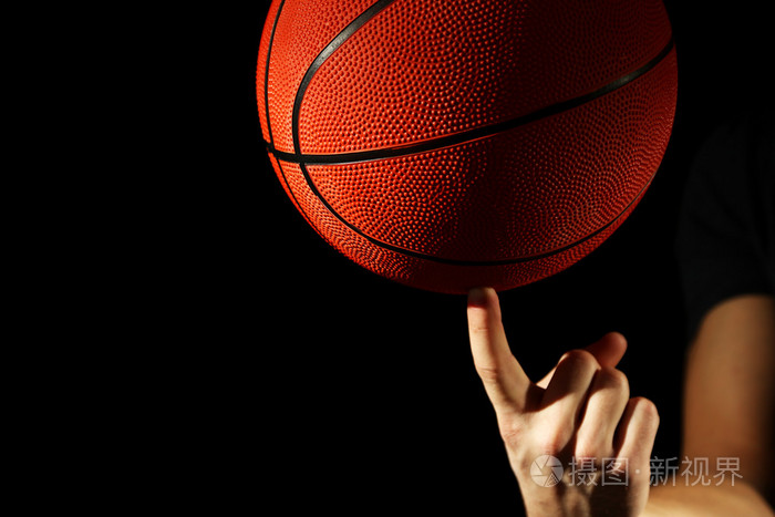 篮球运动员握球，在深色背景上