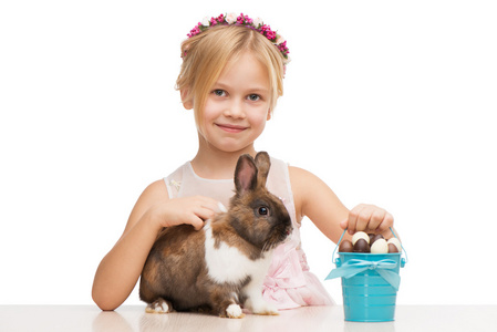 小女孩微笑着与兔和巧克力蛋