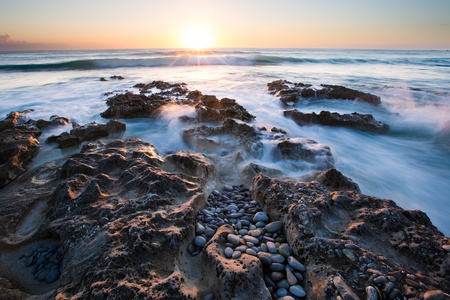 清晨的多岩石的海岸和发光苏海洋景观