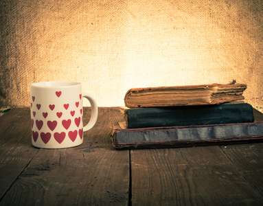 白色杯子，许多照片中的心和一叠旧书籍日
