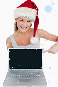 一个戴着圣诞帽的女人指着笔记本的合成图像