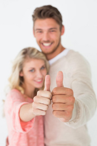 幸福的年轻夫妇竖起大拇指