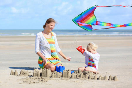 快乐的妈妈和孩子在海滩上玩耍