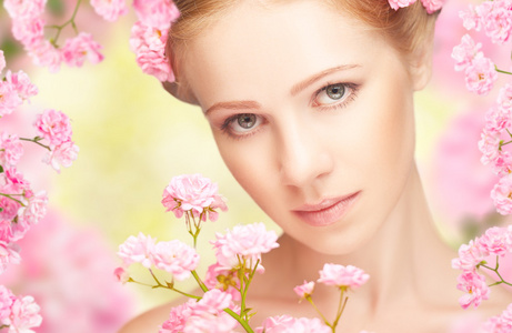 美脸的年轻美丽的女子和粉色的花朵在她哈哈