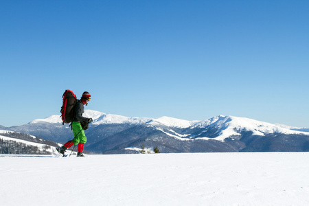 在山里徒步旅行带着背包和帐篷雪的冬天