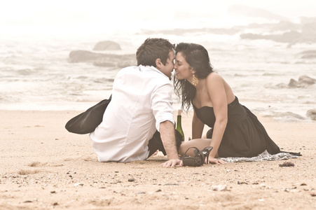 年轻美丽的吸引力夫妇一起在沙滩上调情