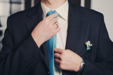 男人的手绑他的领带结的特写图片