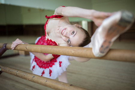 使伸展双腿靠近的芭蕾舞演员的肖像照片