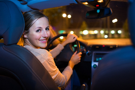 女人在夜间驾驶她的新车