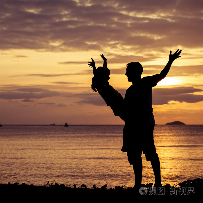 父亲和女儿站在沙滩上