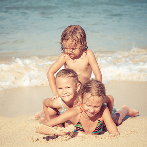 快乐的孩子在一天时间在沙滩上玩