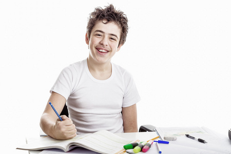 十几岁男孩微笑和写作作业