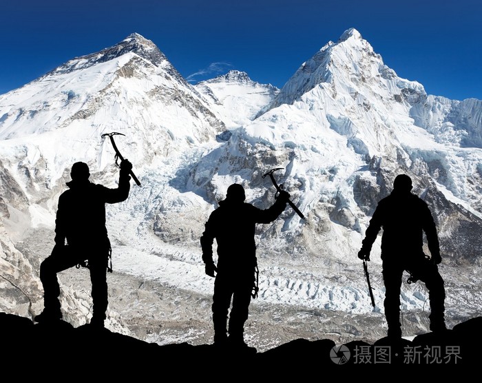 男子用冰斧在手登上珠穆朗玛峰的剪影
