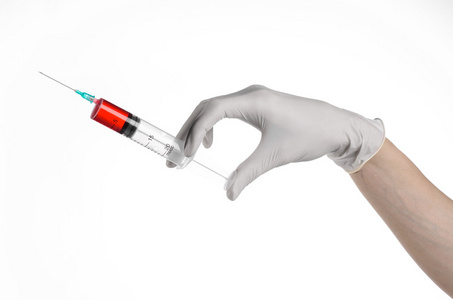 医生的手拿着注射器，戴着白手套的手，一大注射器 医疗问题，医生使注射，白色背景，孤立 白手套医生 埃博拉病毒测试，红药