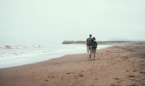 恩爱的夫妻在海滩上行走