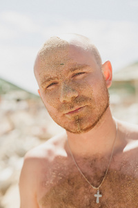 半边脸的沙子覆盖一个英俊的男人