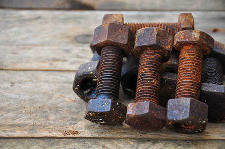 旧的螺栓或脏螺栓在木制的背景下，机械设备行业工作